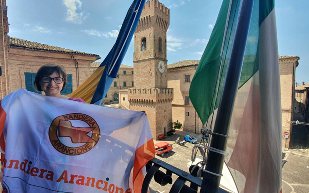 La sindaca di Ostra Federica Fanesi con la bandiera arancione 2021 del Touring Club Italiano