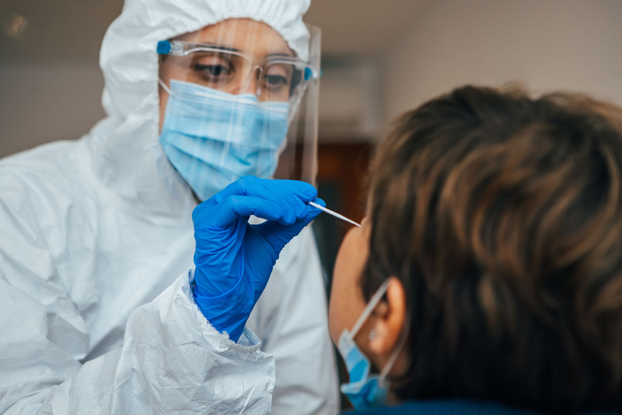 Protected health professional Testing for Coronavirus a patient. Foto di Adobe Stock