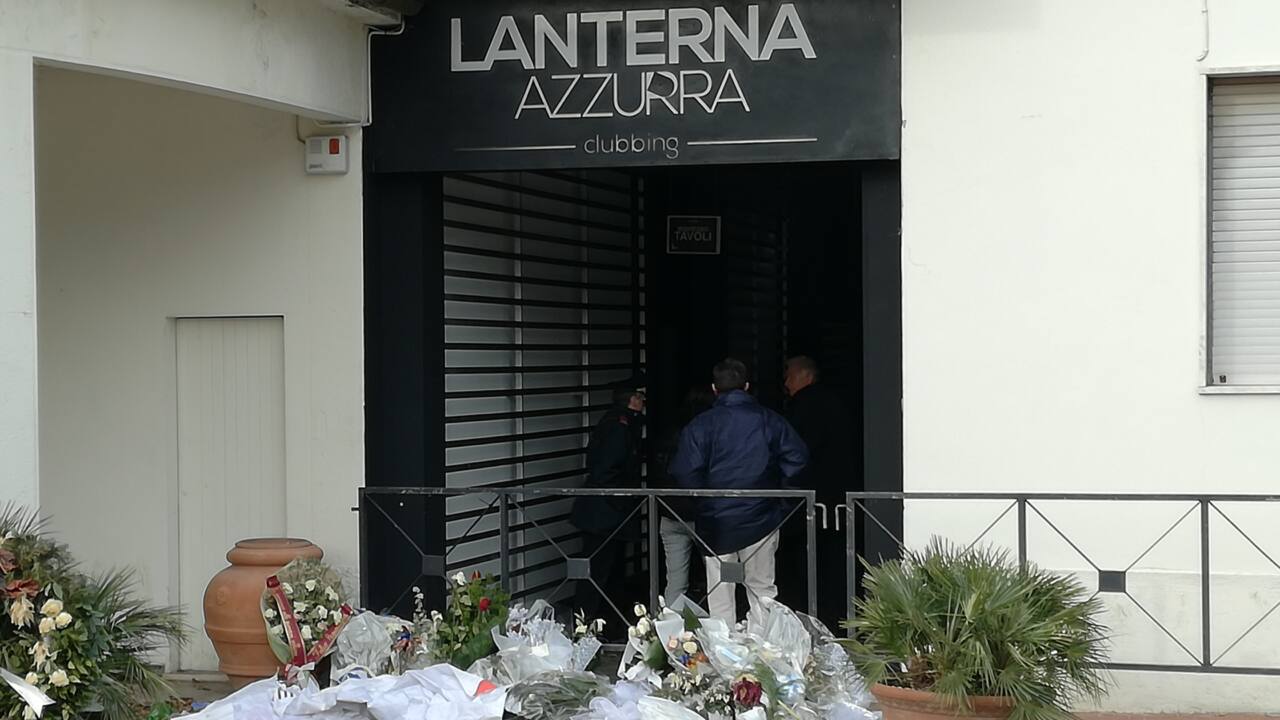Il sopralluogo di inquirenti e forze dell'ordine alla Lanterna Azzurra di Corinaldo l'8 gennaio 2019. All'ingresso i mazzi di fiori per le giovani vittime